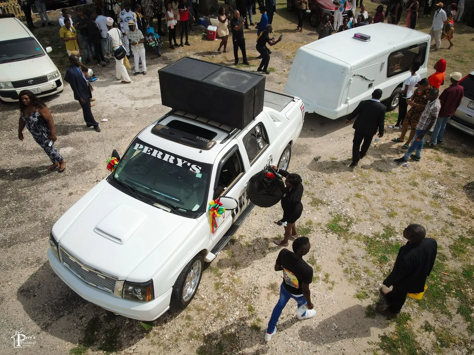 Perry's funeral vehicle positioned within a large public gathering